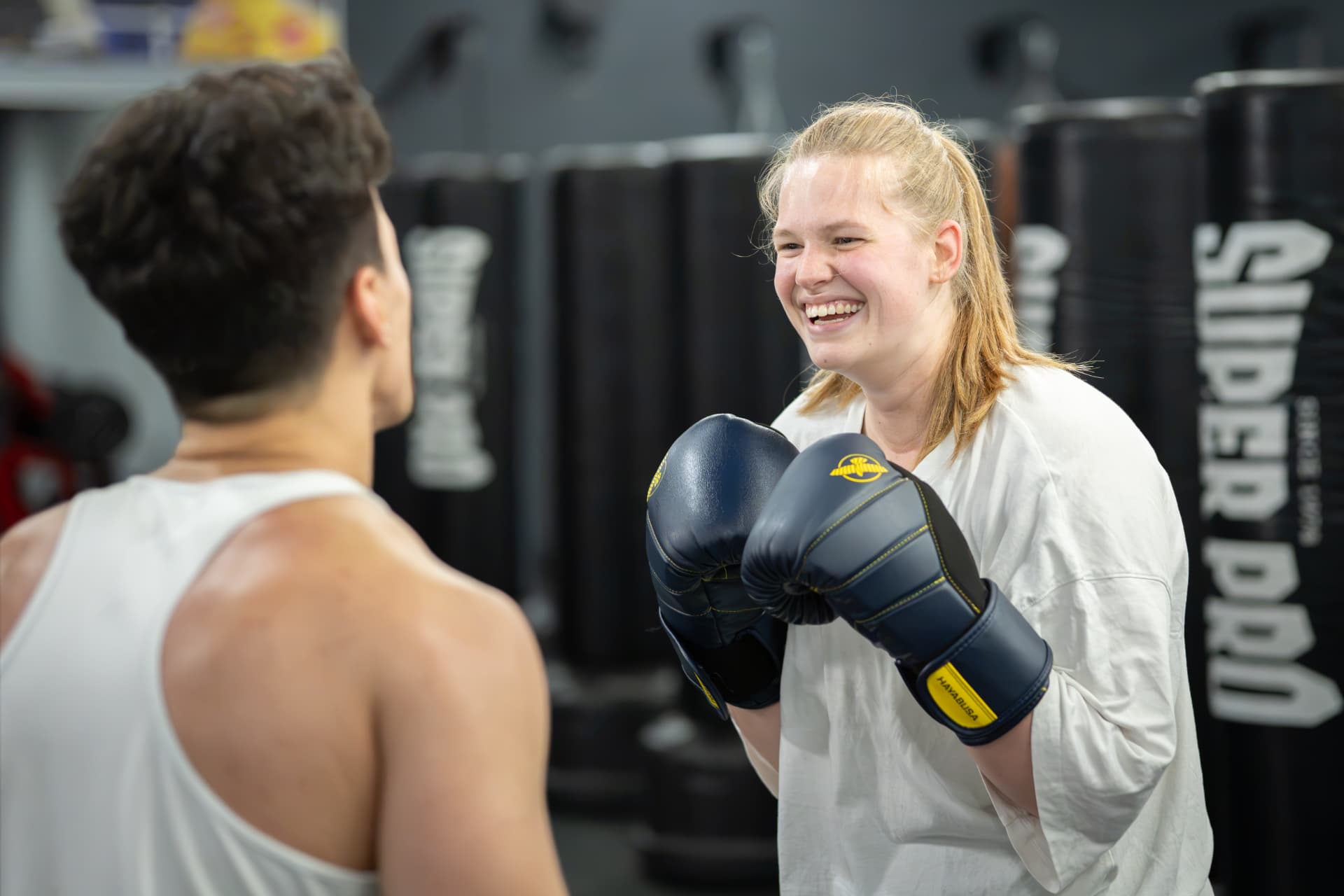 Trainer geeft handschoentraining aan een beginner tijdens de gratis proefles